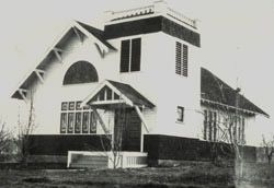 An old black and white photo of the first church at it's dedication.